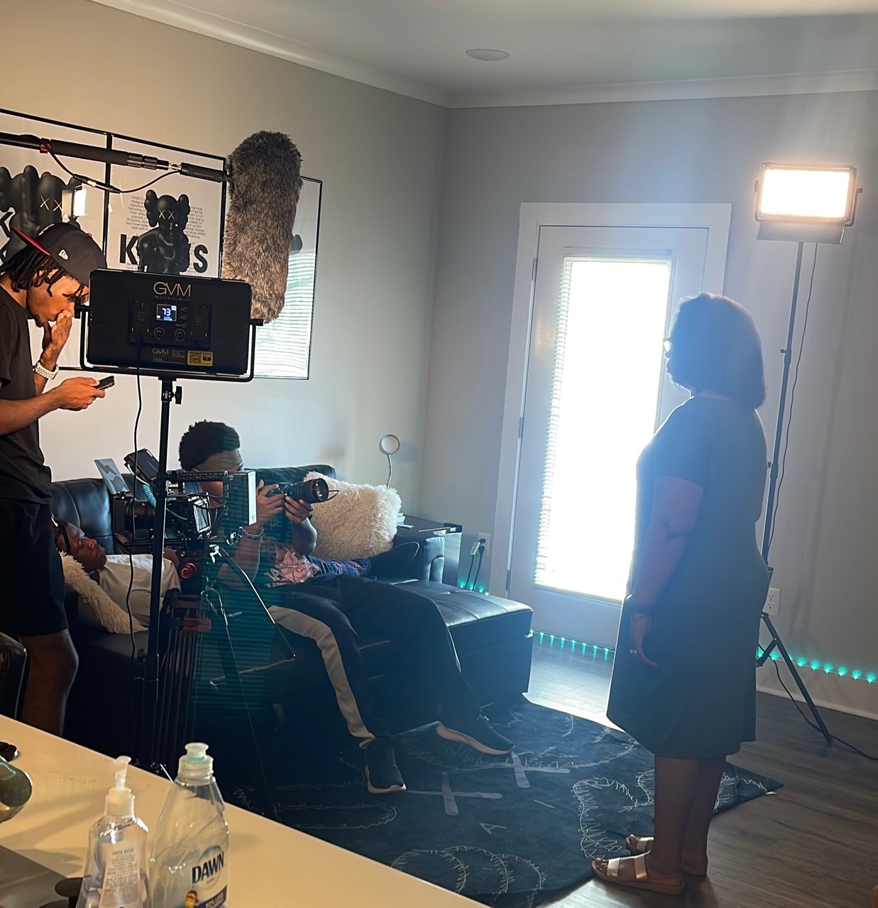 Cast and crew work around a camera on an indoor set.