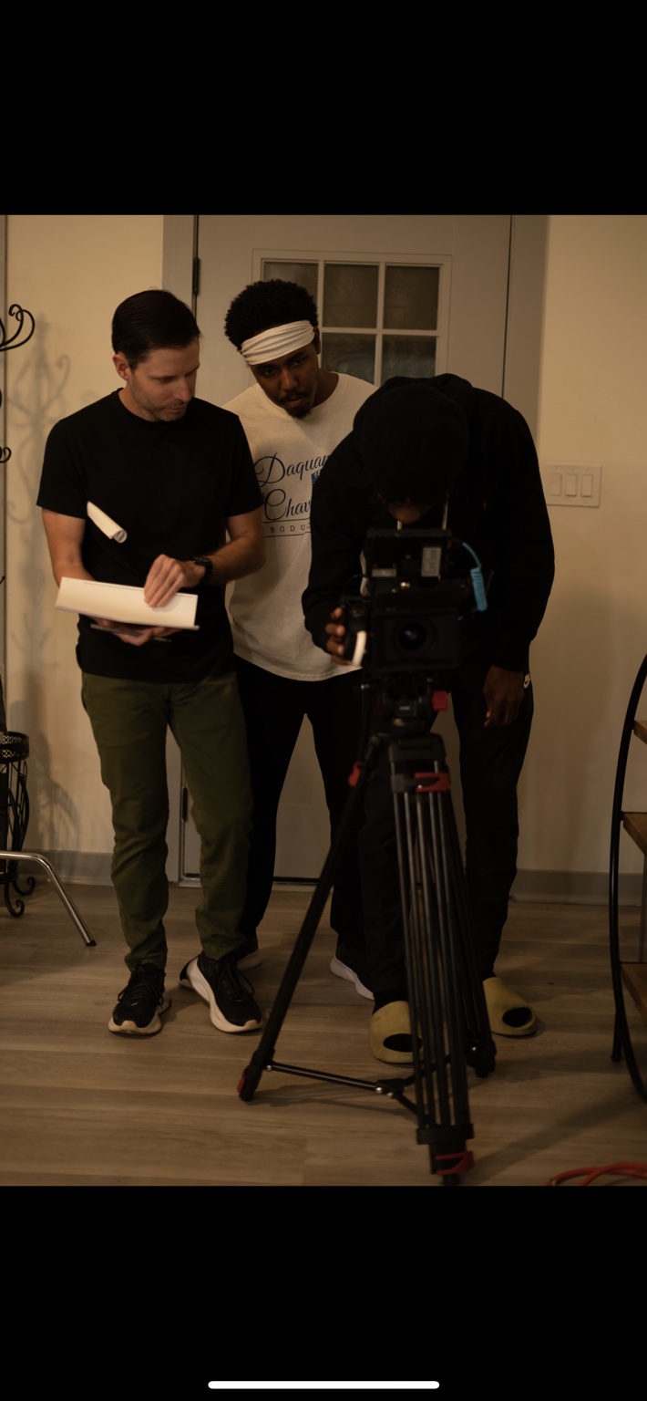 Crew members review the camera setup on an indoor set.