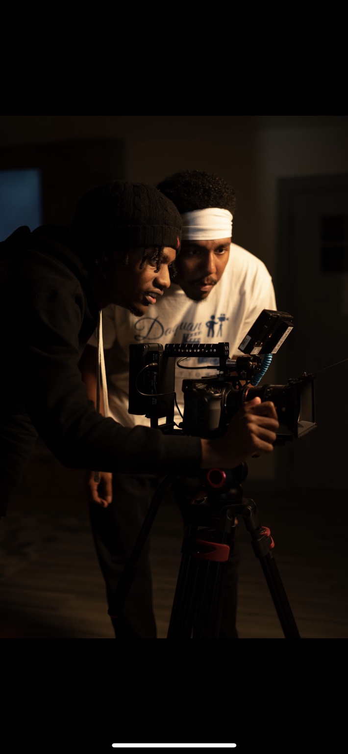 Crew members work together around a cinema camera.