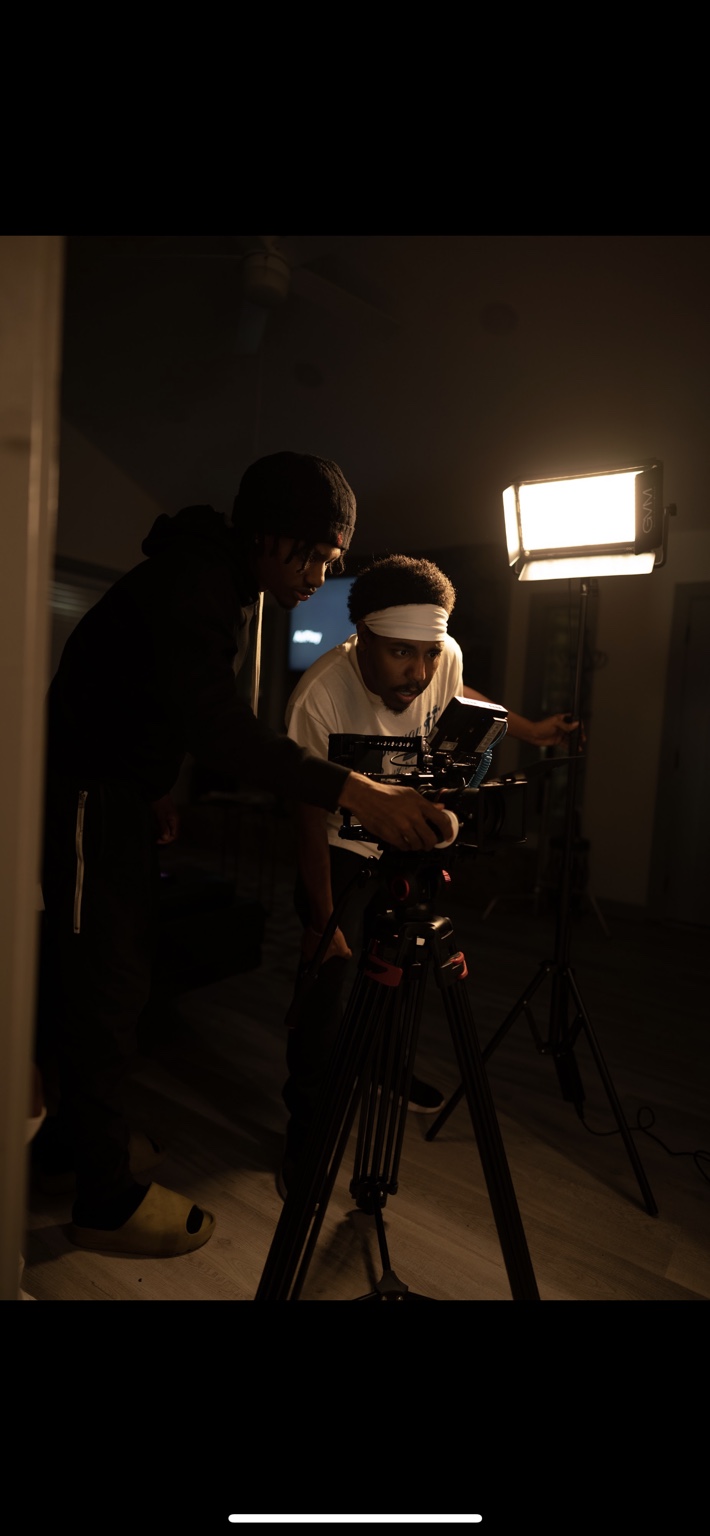 Two crew members study a cinema camera monitor.